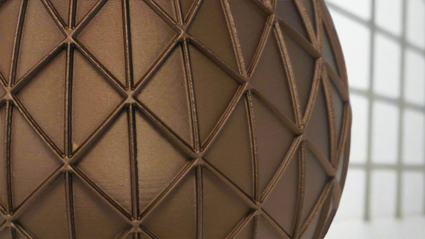 Close-up of a brown textured sphere with geometric pattern on a white background